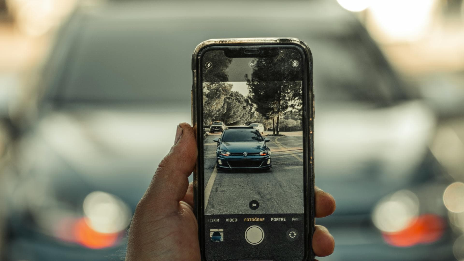Person photographing their car with a smartphone