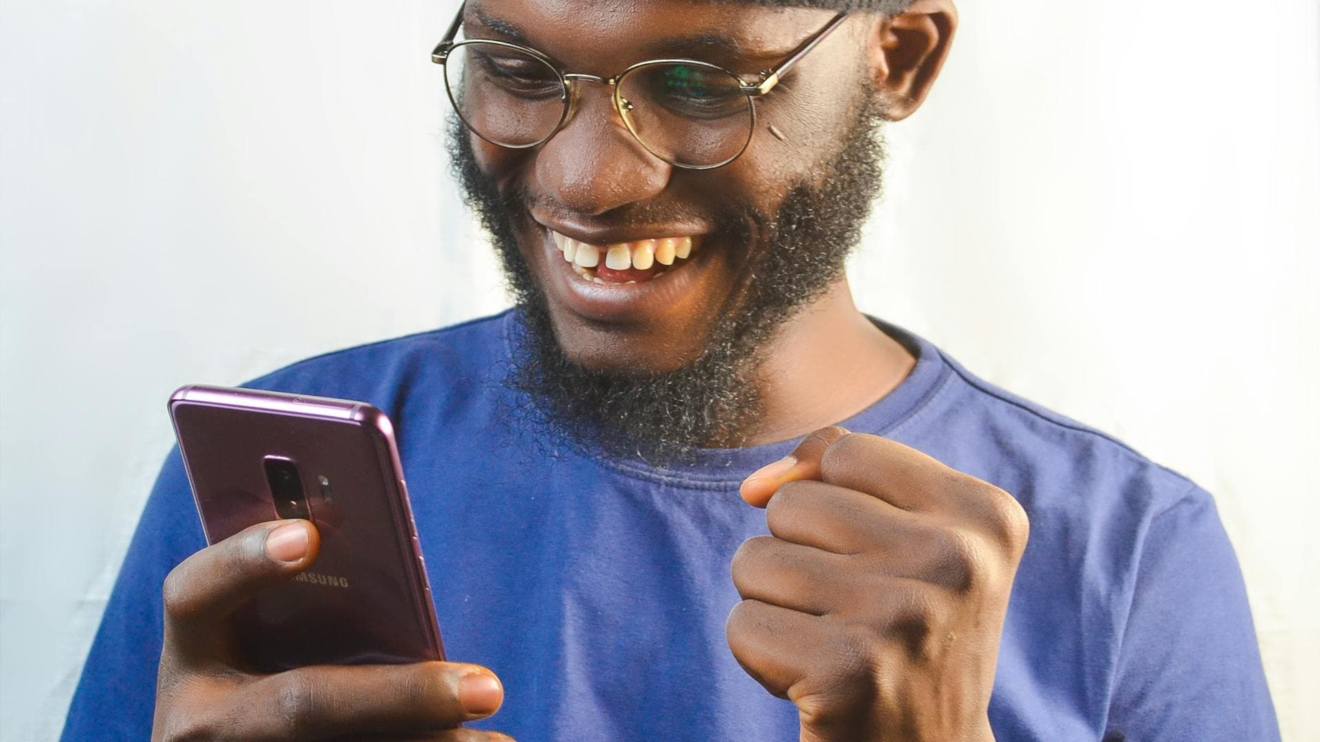 Happy man excited by good news on his phone